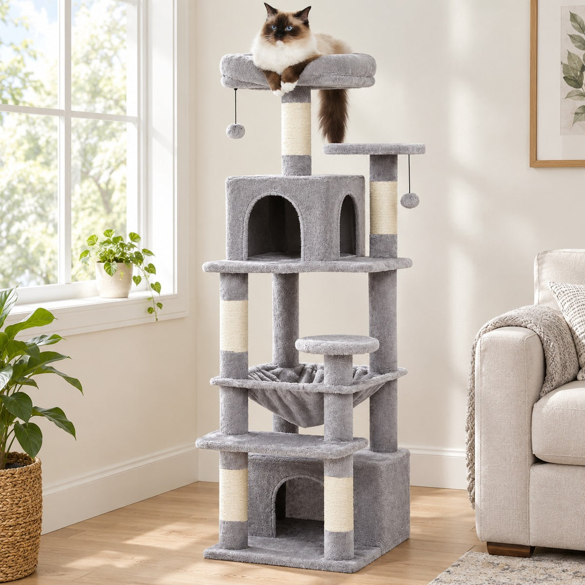 Cat resting on the top perch of a 53.5 in grey cat tree tower with hammock and two condos