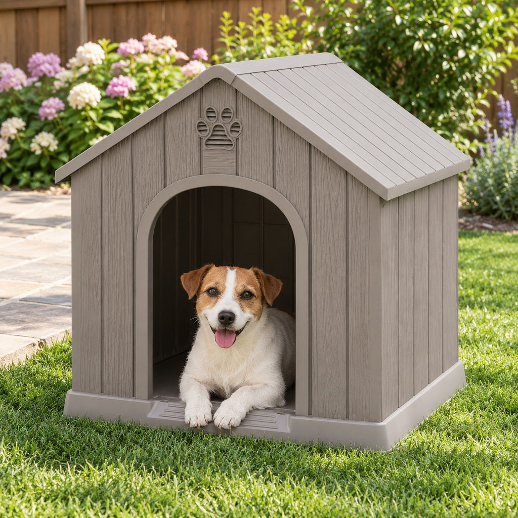 Dog resting in the doorway of a gray plastic dog house on a backyard lawn