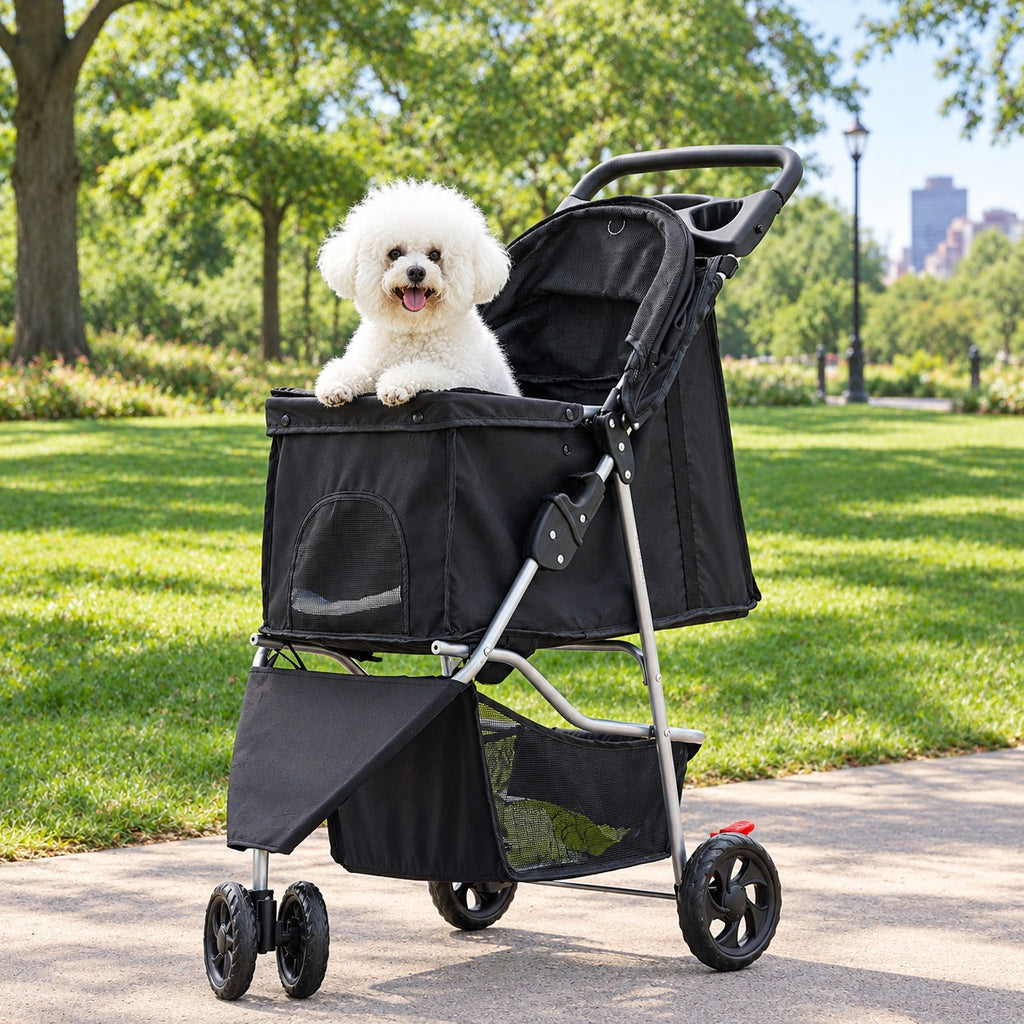 Dog sitting in a black 3-wheel pet stroller parked on a park path